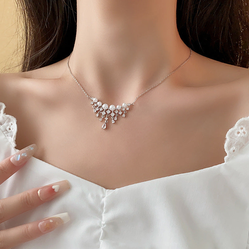 Halsband med gnistrande pärlor och droppformade zirkoner