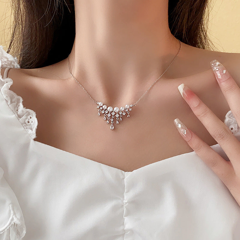 Halsband med gnistrande pärlor och droppformade zirkoner