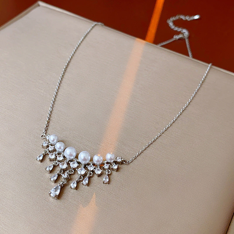 Halsband med gnistrande pärlor och droppformade zirkoner